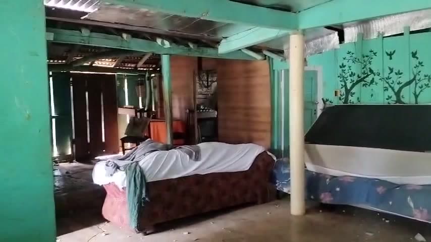 Interior de la casa con camas y paredes dañadas