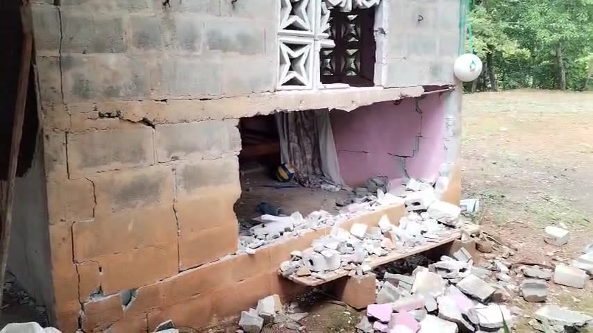 Pared de bloques derrumbada por el terremoto, con escombros en el suelo